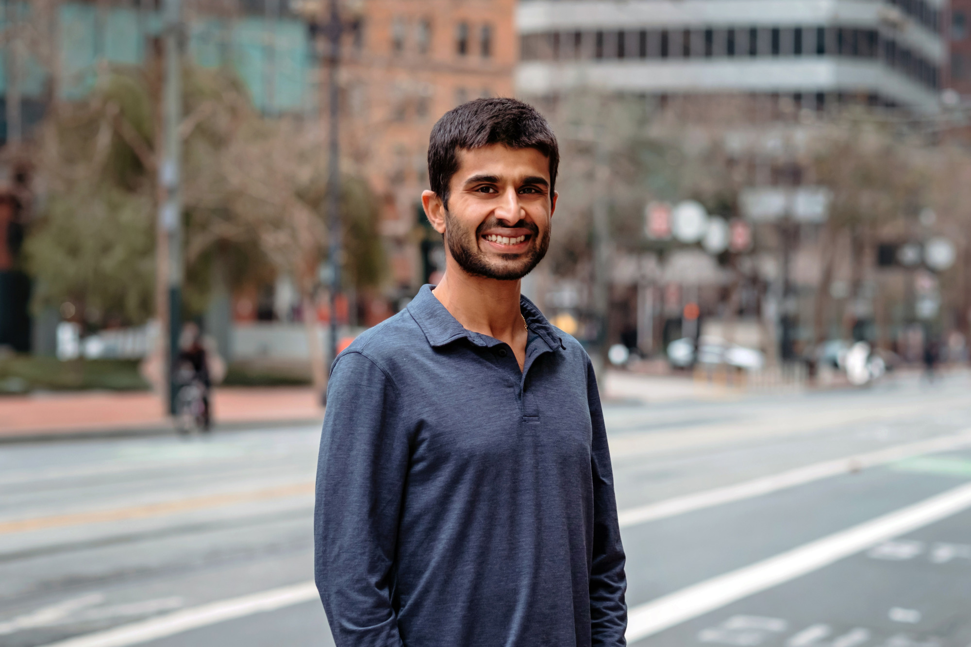 Staff member Rohit Naimpally wearing a grey shirt posing on a San Francisco street.